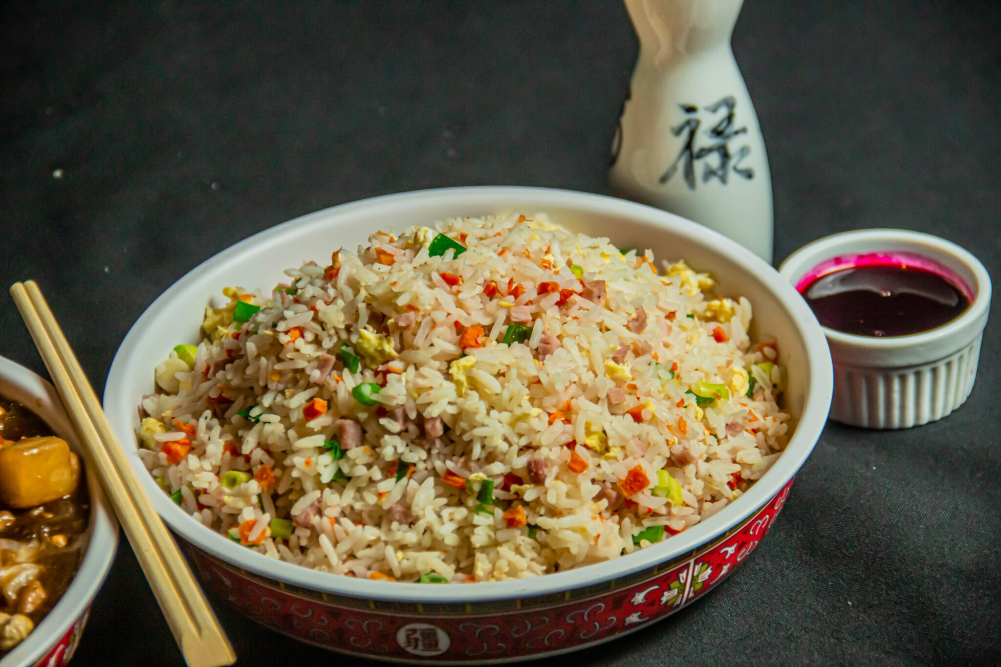 A vibrant bowl of Asian-style fried rice served with traditional condiments for a mouthwatering experience.